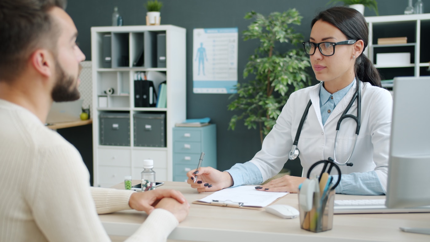 Un professionnel de santé passe en revue les détails avec un patient à l'accueil d'une clinique
