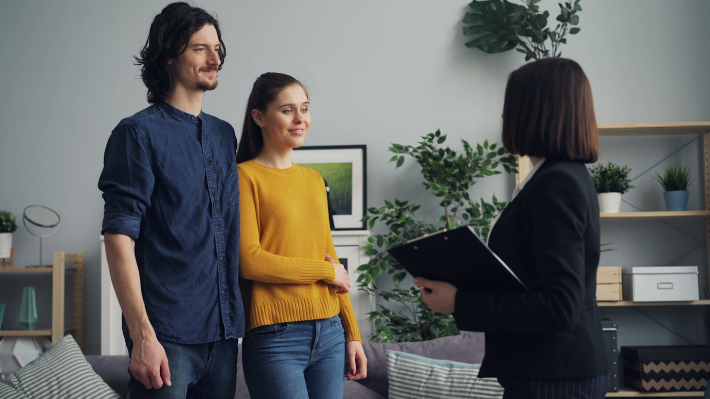A real estate agent going over details with a couple in their home